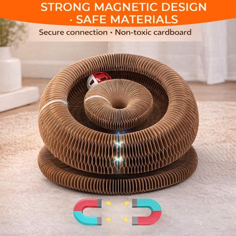 Op de afbeelding: Een bruin katten speeltje van golfkarton met een cirkelvormig ontwerp. Het speelgoed heeft een centraal donutvormig gedeelte en een kleine rood-witte bal. De tekst bovenaan luidt "STRONG MAGNETIC DESIGN - SAFE MATERIALS".