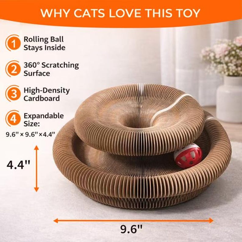 Op de afbeelding: Een bruin kartonnen kattenspeeltje met een rollende bal. Het speelgoed is 24,4 cm x 24,4 cm x 11,2 cm groot en heeft een 360&deg; kraboppervlak. De tekst "WHY CATS LOVE THIS TOY" staat bovenaan.