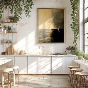 May include: A white kitchen with white cabinets, a gold faucet, and a large framed painting of a sailboat on the water. The painting has a gold frame and a light brown background. There are two bar stools in the foreground.