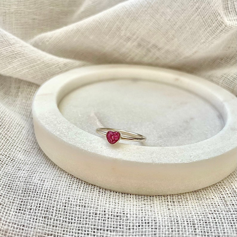 Peut inclure: Une bague en argent avec une pierre en forme de c&oelig;ur rose.