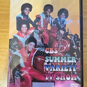 May include: DVD cover featuring The Jacksons on a CBS Summer Variety TV Show. The cover features a photo of the band in colorful outfits, with a motorcycle in the background. The text "CBS Summer Variety TV Show" is printed in large, colorful letters.