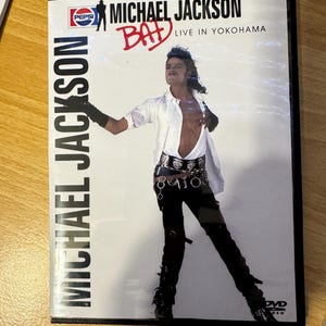 May include: A DVD case featuring Michael Jackson with the text "Michael Jackson Bad Live in Yokohama" and a Pepsi logo. The background is white and the case is black.