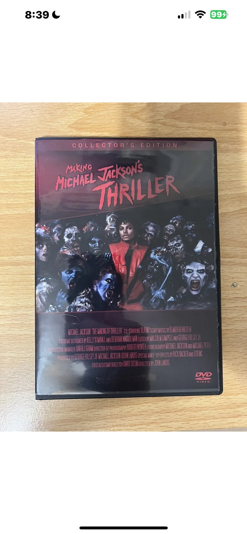 Puede incluir: Una caja de DVD para el documental "Making Michael Jackson's Thriller". La portada presenta una imagen en blanco y negro de Michael Jackson rodeado de zombies. El texto "COLLECTOR'S EDITION" est&aacute; impreso en blanco sobre un fondo rojo.