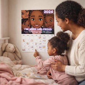 Peut inclure: Calendrier 2026 avec une illustration de filles souriantes à la peau brune. Le texte "I'M MIXED AND PROUD" et "Twice the heritage, tinge the richness" est au-dessus de la grille du calendrier. Une mère et son enfant regardent le calendrier.
