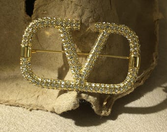 Broche vintage Valentino redondo con doble letra y diamantes de imitación en tono dorado