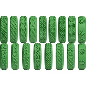 Puede incluir: Una colecci&oacute;n de diecis&eacute;is sellos cil&iacute;ndricos verdes, cada uno con un patr&oacute;n geom&eacute;trico o de nudos celtas en relieve &uacute;nico en su superficie. Estas herramientas individuales est&aacute;n dispuestas en dos filas de ocho, mostrando diversos dise&ntilde;os.