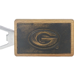May include: A wooden bottle opener with a metal opener and a distressed black and gold Green Bay Packers logo.