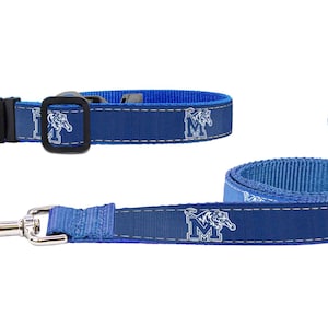 May include: Blue dog collar and leash set. The collar has a black buckle and the leash has a silver clasp. Both items are blue with a white tiger logo and the letter "M".