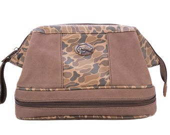 Neceser Bass para hombre. Lona encerada marrón con acabado de camuflaje clásico. Logotipo de cobre antiguo.