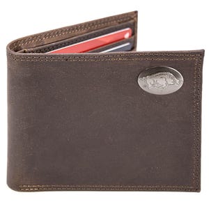 Puede incluir: Una cartera de cuero marrón con un emblema plateado. La cartera plegable está abierta, revelando tarjetas de crédito. La cartera tiene un borde cosido y un aspecto texturizado. El emblema es de forma ovalada.