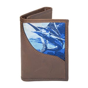 Puede incluir: Cartera de cuero marrón con un diseño de pez vela azul y blanco. La cartera está abierta, revelando el interior. El pez vela está representado en detalle, con una combinación de colores azul y blanco. La cartera es de cuero.