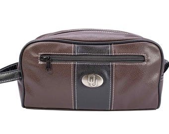 Neceser masculino de los Oklahoma Sooners. Acabado en poliuretano color marrón con textura granulada. Logotipo plateado de la OU. Resistente al agua. Diseño compacto y espacioso.