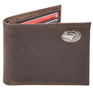 Puede incluir: Una cartera de cuero marrón con un emblema plateado en la parte delantera. La cartera está abierta, revelando varias tarjetas de crédito. Las costuras son visibles alrededor de los bordes. La cartera está hecha de cuero texturizado.