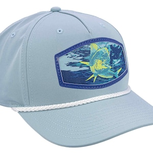 May include: Pale blue baseball cap with a white rope detail and a curved peak. The cap has a rectangular patch with a colourful illustration of a fish. A stylish accessory for outdoor activities.