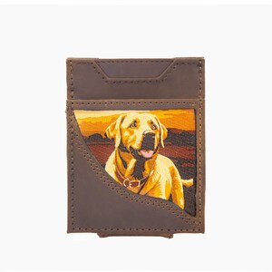 Puede incluir: Tarjetero de cuero marrón con una imagen bordada de un perro Labrador Retriever amarillo. El perro está situado frente a una puesta de sol. El tarjetero tiene un bolsillo delantero y una ranura en la parte trasera.
