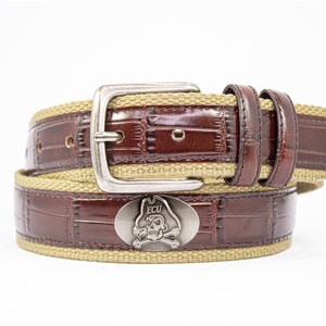 May include: Brown leather belt with a silver buckle and a canvas centre. The belt features a decorative metal emblem with a skull and crossbones design and the letters "ECU". A stylish accessory.