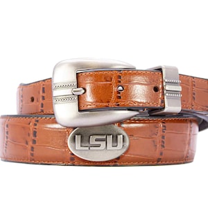 May include: Brown leather belt with a silver buckle and LSU logo. The belt has a crocodile texture and a silver buckle with decorative details. A stylish accessory for everyday wear.