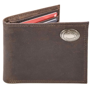 Puede incluir: Una cartera de cuero marrón con un emblema plateado. La cartera plegable está abierta, revelando ranuras para tarjetas con tarjetas visibles. La cartera tiene un borde cosido y un acabado envejecido.