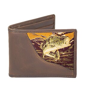 Puede incluir: Cartera de cuero marrón de dos pliegues con un panel decorativo que presenta una ilustración de un pez saltando en tonos verdes, amarillos y marrones. La cartera tiene múltiples ranuras para tarjetas y un compartimento para billetes.