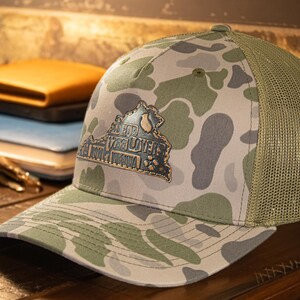 Virginia Map Old School Camo Trucker Hat. Burnished Full Grain Leather Patch. 5-Panel Richardson 112 Snapback Cap. Stitched Map Patch.