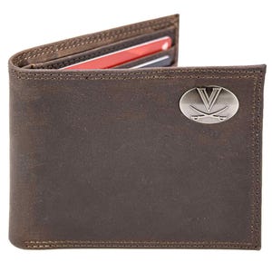 Puede incluir: Cartera de cuero marrón con un emblema plateado en la parte delantera. La cartera está abierta, revelando ranuras para tarjetas con tarjetas rojas y negras. Los bordes están cosidos con un hilo en contraste. La cartera es de estilo plegable.