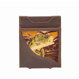 Puede incluir: Una cartera de cuero marrón con un gráfico de pez colorido. La cartera presenta un diseño rectangular con una ranura para tarjetas y una ilustración detallada de un pez en tonos verdes, amarillos y marrones.