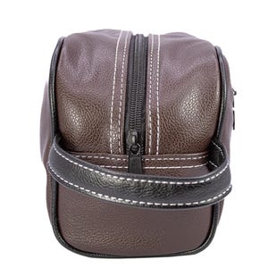 Puede incluir: Neceser de cuero marr&oacute;n con cremallera y asa negras. La bolsa tiene costuras blancas y un ribete negro. Dise&ntilde;ado para guardar art&iacute;culos de aseo y objetos personales.