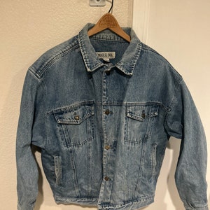 May include: A light blue denim jacket with a button closure and a