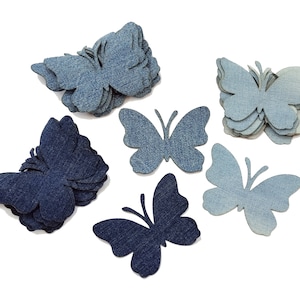 Pode incluir: Cinco formas de borboleta de ganga em vários tons de azul. As borboletas são sobrepostas e dispostas em um grupo sobre um fundo branco.