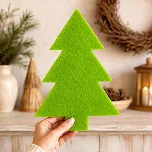 Può includere: Una sagoma in feltro verde lime brillante a forma di albero di Natale stilizzato. L'oggetto piatto e triangolare presenta una punta superiore e due rami a gradini, che terminano in una base rettangolare. Il materiale ha una texture visibile e leggermente pelosa.