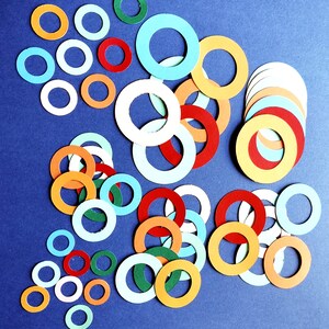 May include: A collection of colorful paper circles in various sizes and shades of blue, red, orange, and green. The circles are arranged in a random pattern on a blue background.