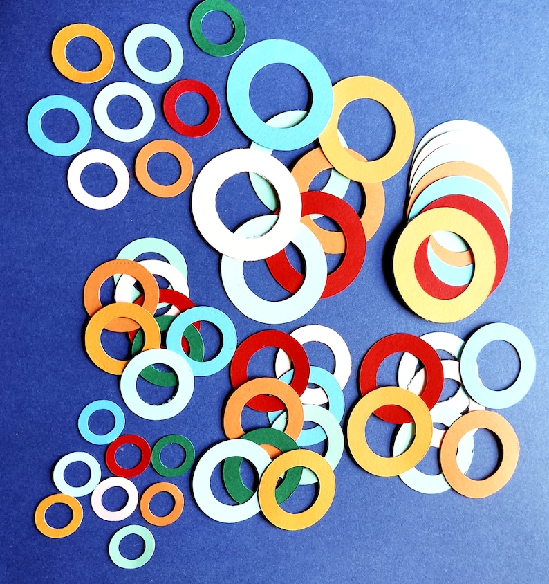 May include: A collection of colorful paper circles in various sizes and shades of blue, red, orange, and green. The circles are arranged in a random pattern on a blue background.