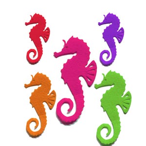 May include: Five felt seahorse shapes in different colors: red, orange, pink, green, and purple. The seahorses are all facing the right side of the image.