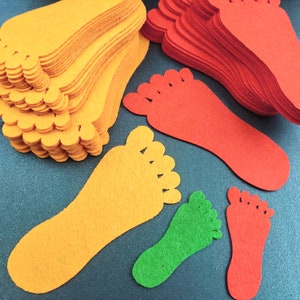 May include: A collection of die-cut felt shapes in the form of human footprints. The set includes multiple stacks and individual pieces in vibrant orange, bright red, and lime green colors, featuring five distinct toe shapes on each cutout.