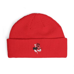 May include: A bright red beanie with a ribbed knit texture. The beanie features a white and red graphic of a snake and crown, with the word "ELITE" in a black rectangle. The hat is a winter accessory.