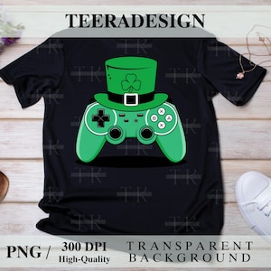 May include: A black t-shirt with a green video game controller wearing a green leprechaun hat. The controller has the letters A, B, X, and Y on it. The hat has a green shamrock on it.