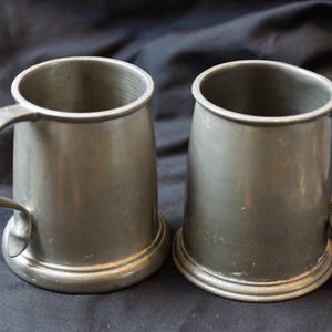 Pair of Tudric (Liberty of London) glass bottomed pewter tankards