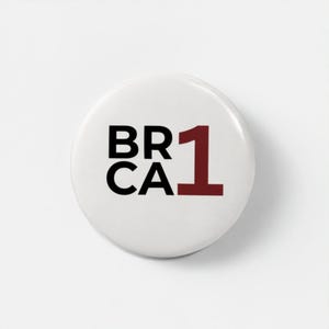 May include: A white round button with the text "BR CA" in black and the number "1" in maroon. The button is a simple design, likely for a pin or badge.