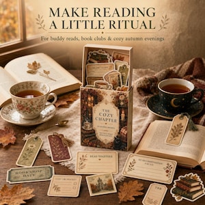 May include: A box set titled The Cozy Chapter containing various paper reading prompts, bookmarks, and cards with autumn-themed illustrations. The set includes items labeled Bookshop Date, Read Together, and My Recommendation For You, surrounded by tea cups.