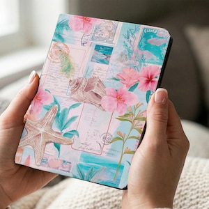 Puede incluir: Una funda para tableta con temática floral que presenta una estrella de mar, conchas marinas y flores de hibisco rosa. El diseño incorpora imágenes de sellos postales en tonos azules, rosas y verdes. La funda se sostiene con dos manos.