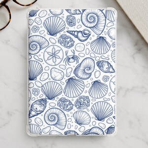 以下が含まれることがあります： 透明なタブレットケースで、ホタテ貝、螺旋状の貝殻、スカシカシパン、小さなカニなど、様々な貝殻を描いた濃い青色の線画が白い背景に繰り返し配置されたデザインが特徴です。