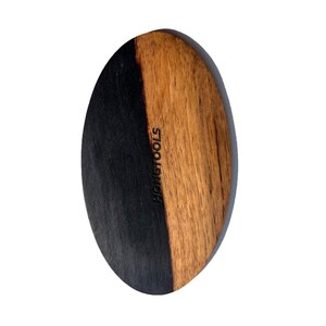 Può includere: Spazzola per toelettatura in legno di forma ovale, divisa verticalmente in due sezioni. Un lato è tinto di nero, l'altro presenta venature naturali del legno. Il testo "HONGTOOLS" è stampato verticalmente sul legno.