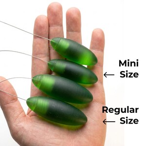 May include: Four green, oblong-shaped objects with attached wires are displayed. The objects are in varying sizes, labeled "Mini Size" and "Regular Size". The objects are held in a hand against a white background.