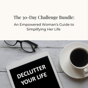 May include: A white tablet with a black screen displaying the text "DECLUTTER YOUR LIFE". The tablet is on a light wood surface with a cup of coffee and a pair of glasses.