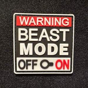 Peut inclure: Un panneau d'avertissement noir et blanc avec du texte rouge qui dit "WARNING BEAST MODE OFF-ON".