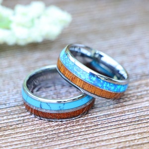 May include: Two silver rings with a blue and brown inlay. The rings are stacked on top of each other.