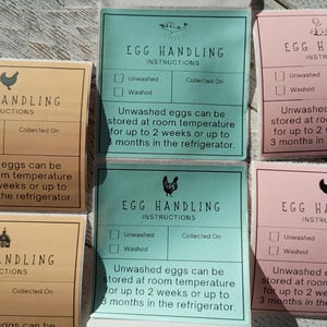 May include: Assortment of egg handling instruction cards in various colors: tan, teal, and pink. Each card features a chicken illustration and text indicating storage guidelines for unwashed and washed eggs.