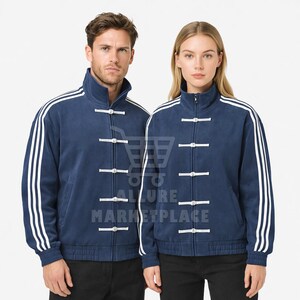 Peut inclure: Veste bleu marine avec des rayures blanches sur les manches et des fermetures à bascule blanches. La veste a un col montant et une fermeture éclair. La veste est portée par deux personnes.