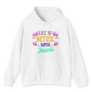 Könnte beinhalten: Weißer Hoodie mit einem Grafikdruck, der "Life is better with Jesus" in bunten Buchstaben mit Blumen um den Text herum sagt.