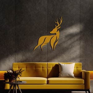 May include: A gold-colored deer silhouette wall decor mounted on a dark gray wall above a yellow sofa with a white pillow.